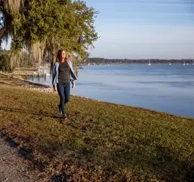 Photo of a person walking along the water banks